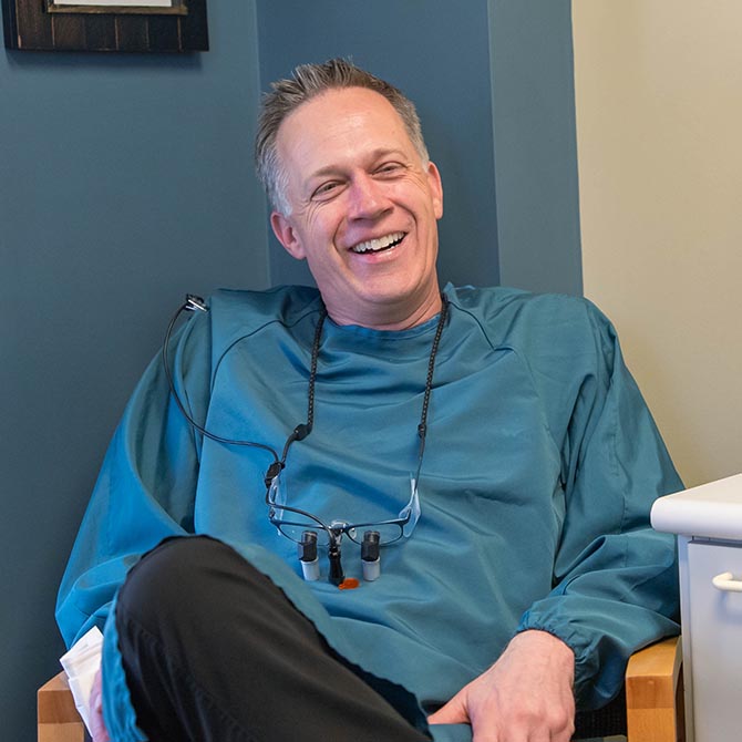 Dr. Adam Fulton of Guilford Hills Dental Care sitting and smiling in a chair